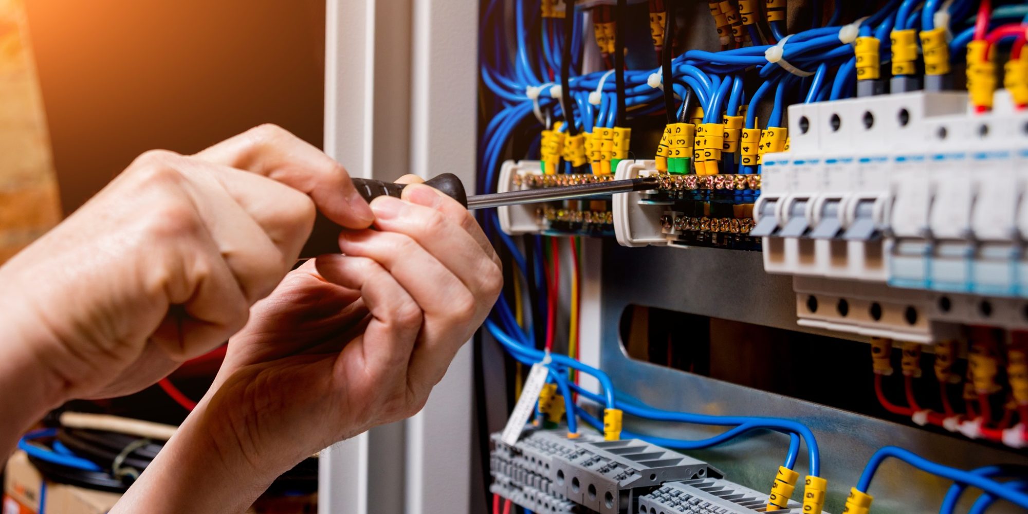 The man is repairing the switchboard voltage with automatic switches. Electrical background